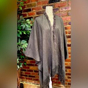 Polyester blend shawl with fringe and rabbit fur trim.